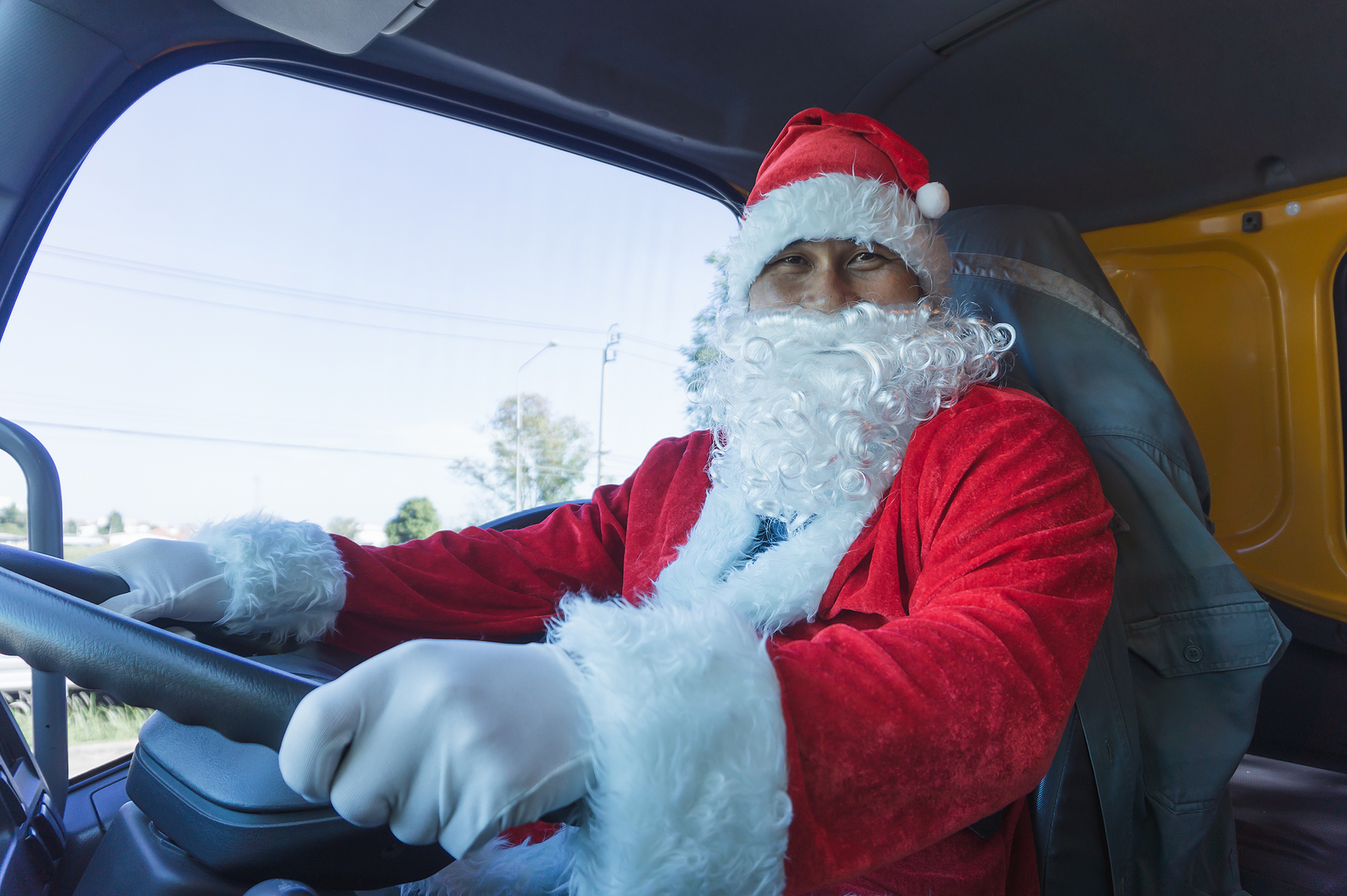 Santa Claus driving a truck. Truck driver wearing Santa Claus and smiling happy on Christmas Day. Workers in transportation and delivery business are working in celebration holidays. Merry Christmas