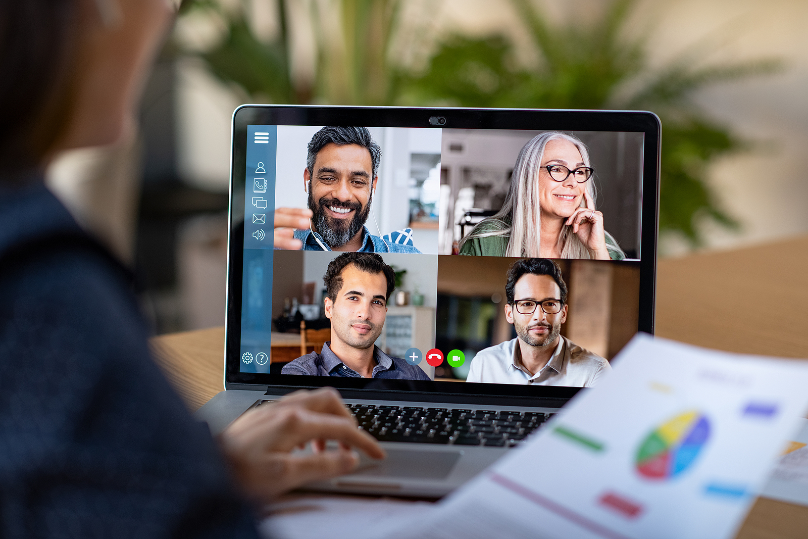 Back view of business woman talking to her colleagues about plan in video conference. Multiethnic business team using laptop for a online meeting in video call. Group of truck driver recruiters working from home